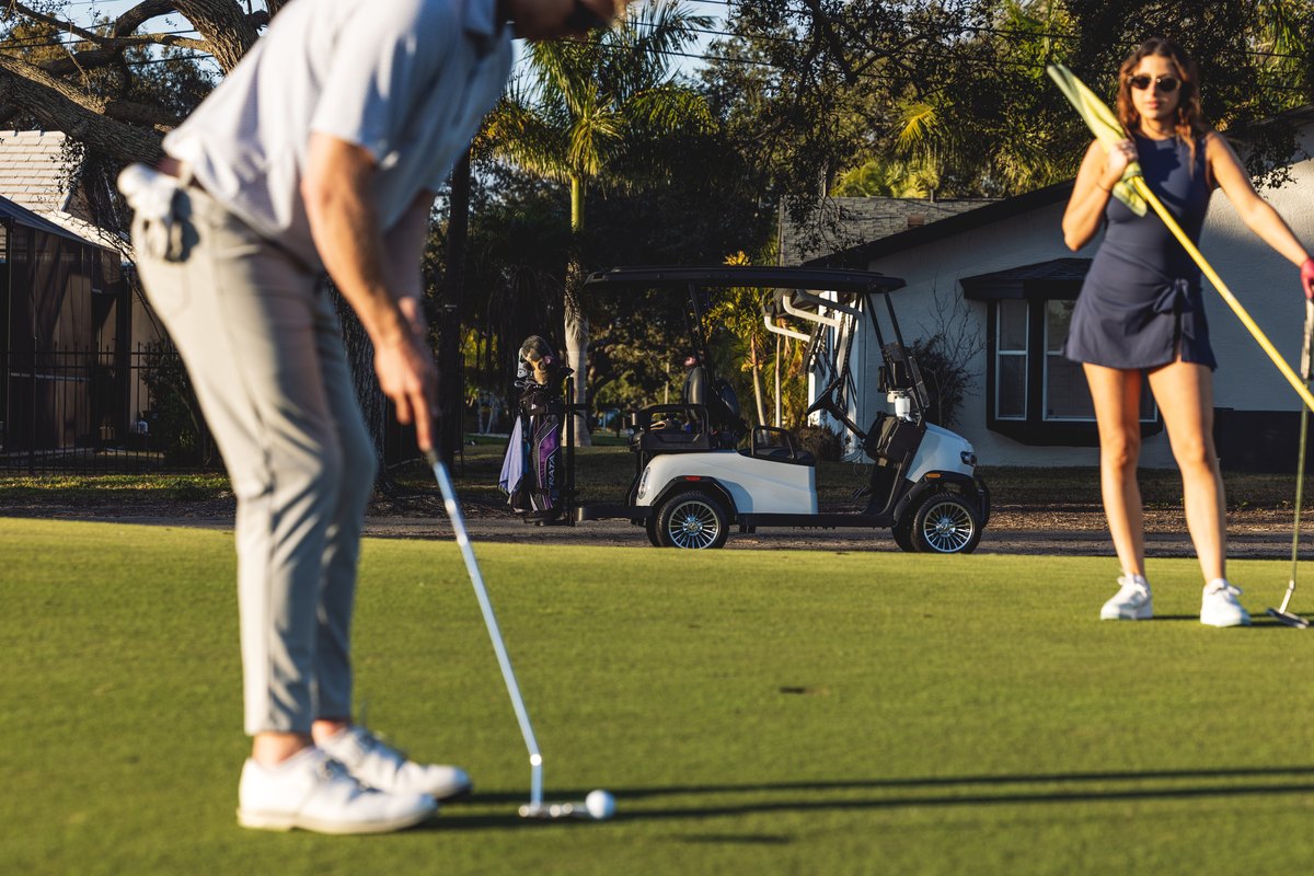 Golfistas en el green junto a un Turbo Lite Golfers putting beside a Turbo Lite